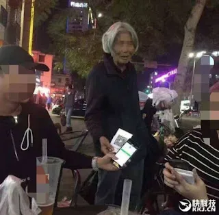 首からQRコードを下げた中国の物乞い